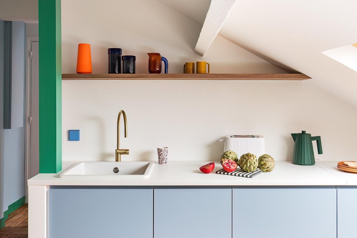 Iceberg blue kitchen with green and brass details, walnut floating shelf