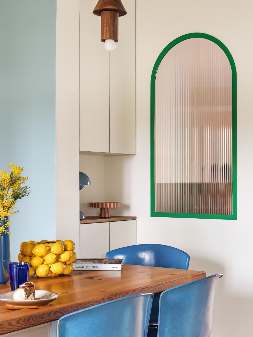 Salle à manger colorée avec fenetre en forme d'arche.