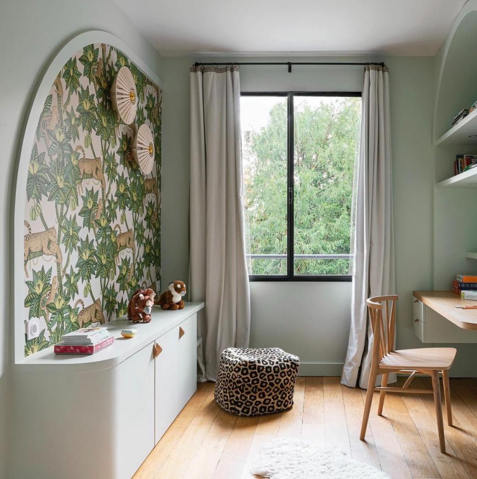 Room with a sideboard and wallpaper on the wall.
