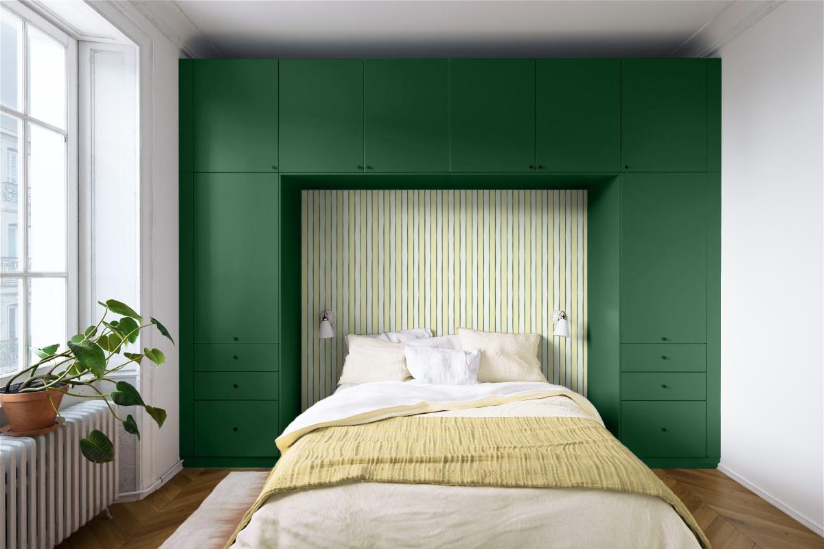 Green headboard with colourful striped wallpaper